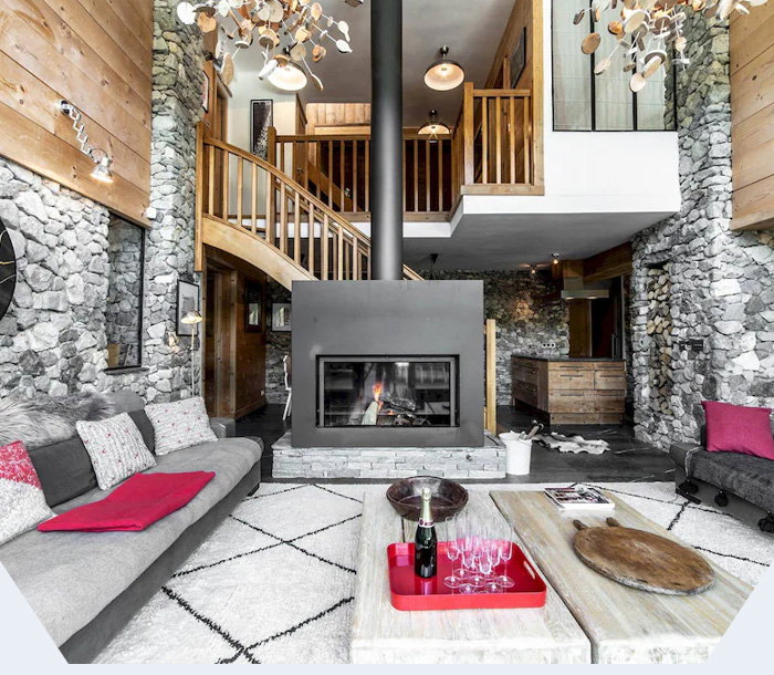 Stone-clad alpine retreat with soaring ceilings, a crackling hearth, and warm timber details inviting connection.
