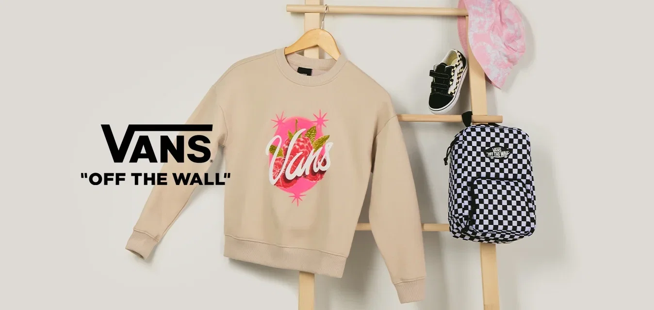 Beiger Vans-Sweatshirt, schwarz-weiß karierten Rucksack, rosa gemusterter Fischerhut und schwarze Babysneaker auf einer Holzleiter präsentiert.