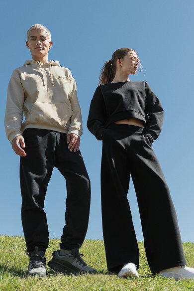 Two models in sweat sets standing outside.