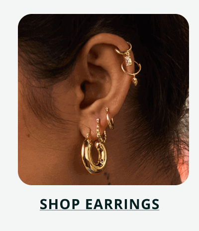 Curated gold ear stack featuring chunky hoops & helix cuffs. Click here to shop earrings