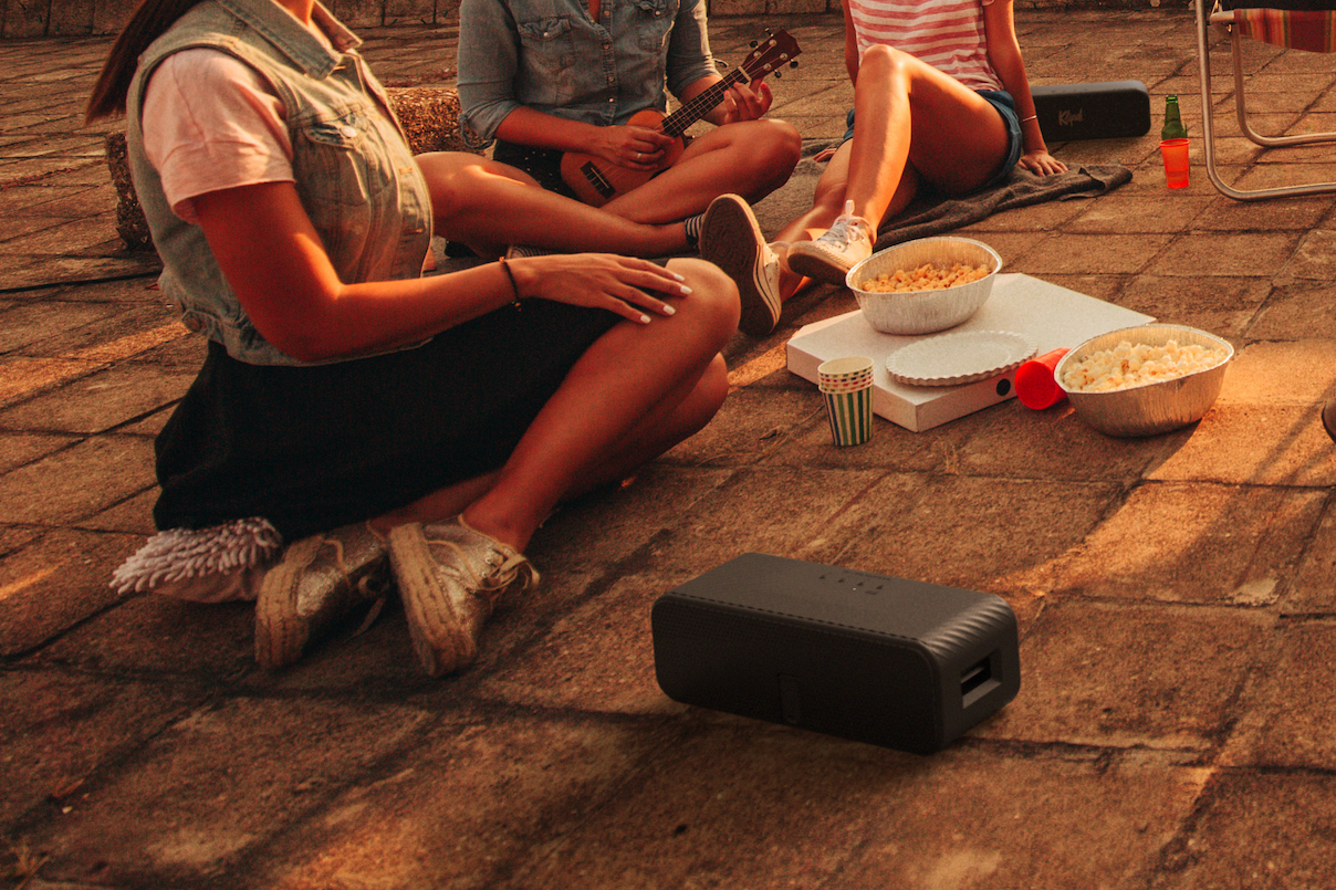 Close-up on Detroit Portable Bluetooth Speaker surrounded by college students.
