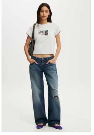 Woman wearing light gray graphic tee and wide-leg jeans