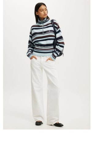 Woman wearing striped sweater and white pants