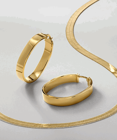 Yellow gold oval hoop earrings and herringbone chain.