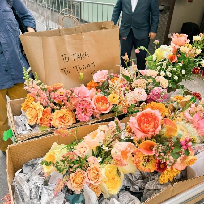Boxes full of colorful bouquets with a sign reading 
