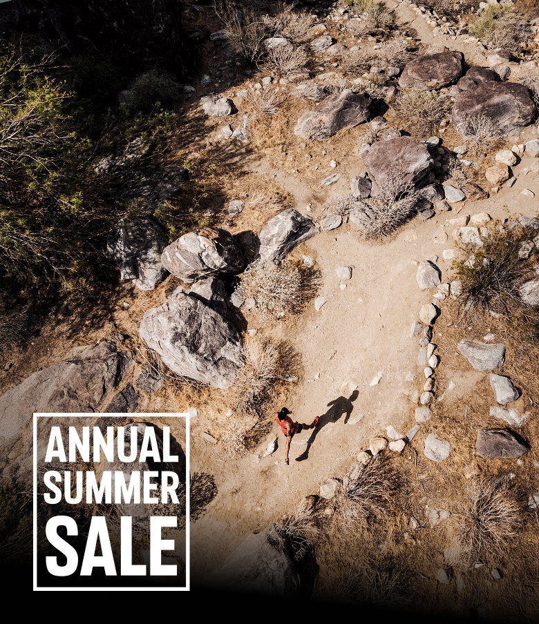 Aerial shot of a runner on a desert trail with ANNUAL SUMMER SALE