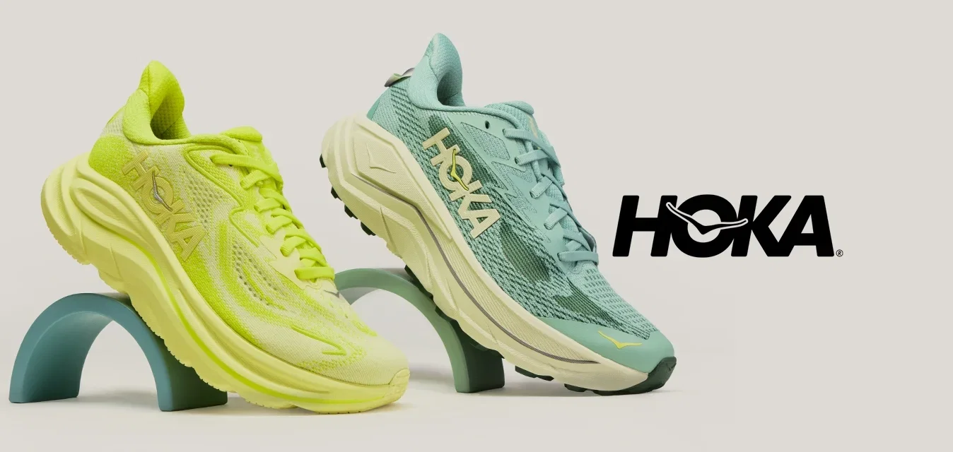 Zwei sportliche Laufschuhe, einer in Neon-Gelb und einer in Türkis, auf geschwungenen Ständern vor einem einfarbigen hellen Hintergrund präsentiert.