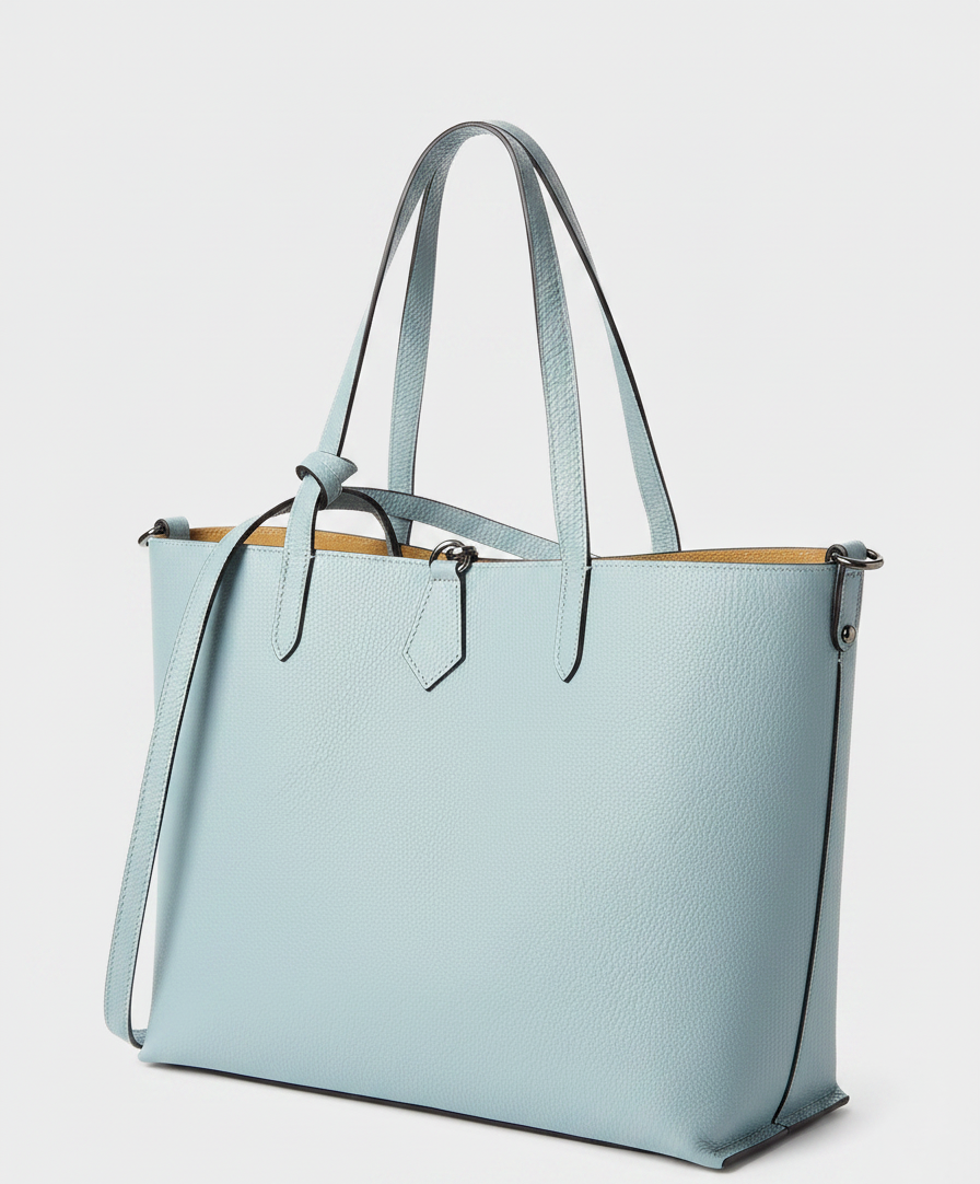 A light blue pebbled leather tote bag with tan interior and shoulder strap.