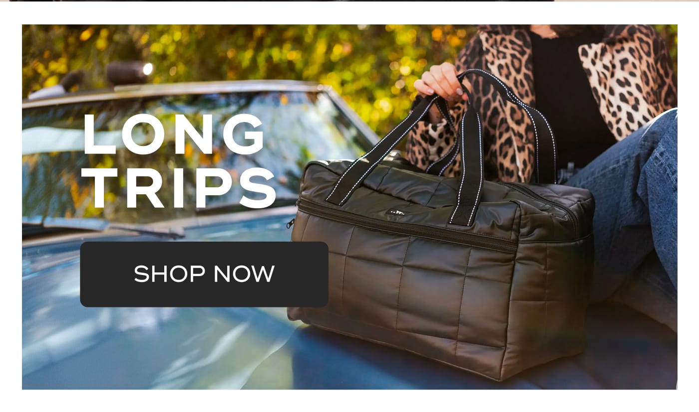 LONG TRIPS. SHOP NOW. Person holding a black quilted SCOUT bag while sitting on the hood of a car.