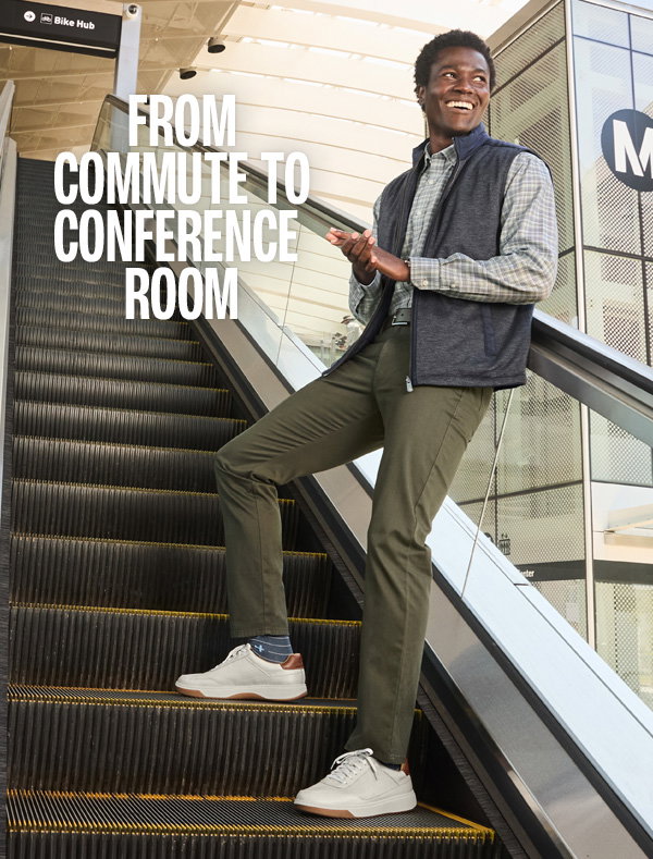 Model wearing a navy vest, plaid shirt, olive pants, and white Dawson sneakers while riding an escalator. Text reads: 