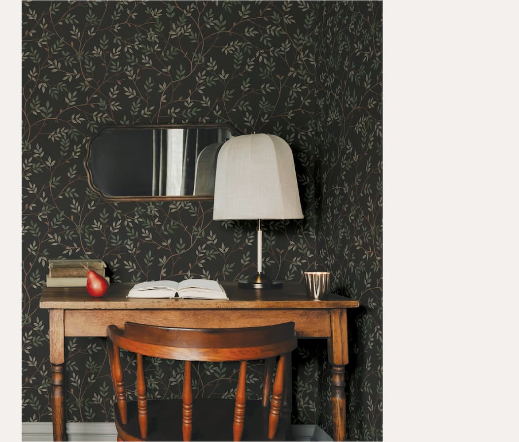 Image of Tempaper's Branches wallpaper in black behind a wood desk. 