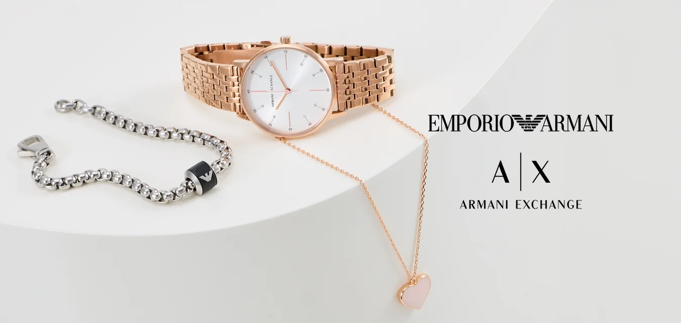 Roze gouden horloge met een mesh-band en een witte wijzerplaat, zilveren schakelarmband met zwarte accenten, en een rozen gouden harthanger ketting.