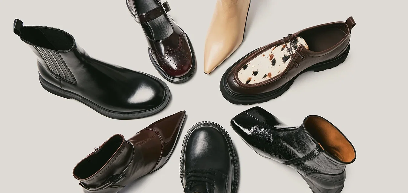 Zeven paren schoenen in verschillende stijlen: leren enkellaarsjes in zwart en bruin, een beige puntige laars en een bruine schoen met een gespikkeld detail.