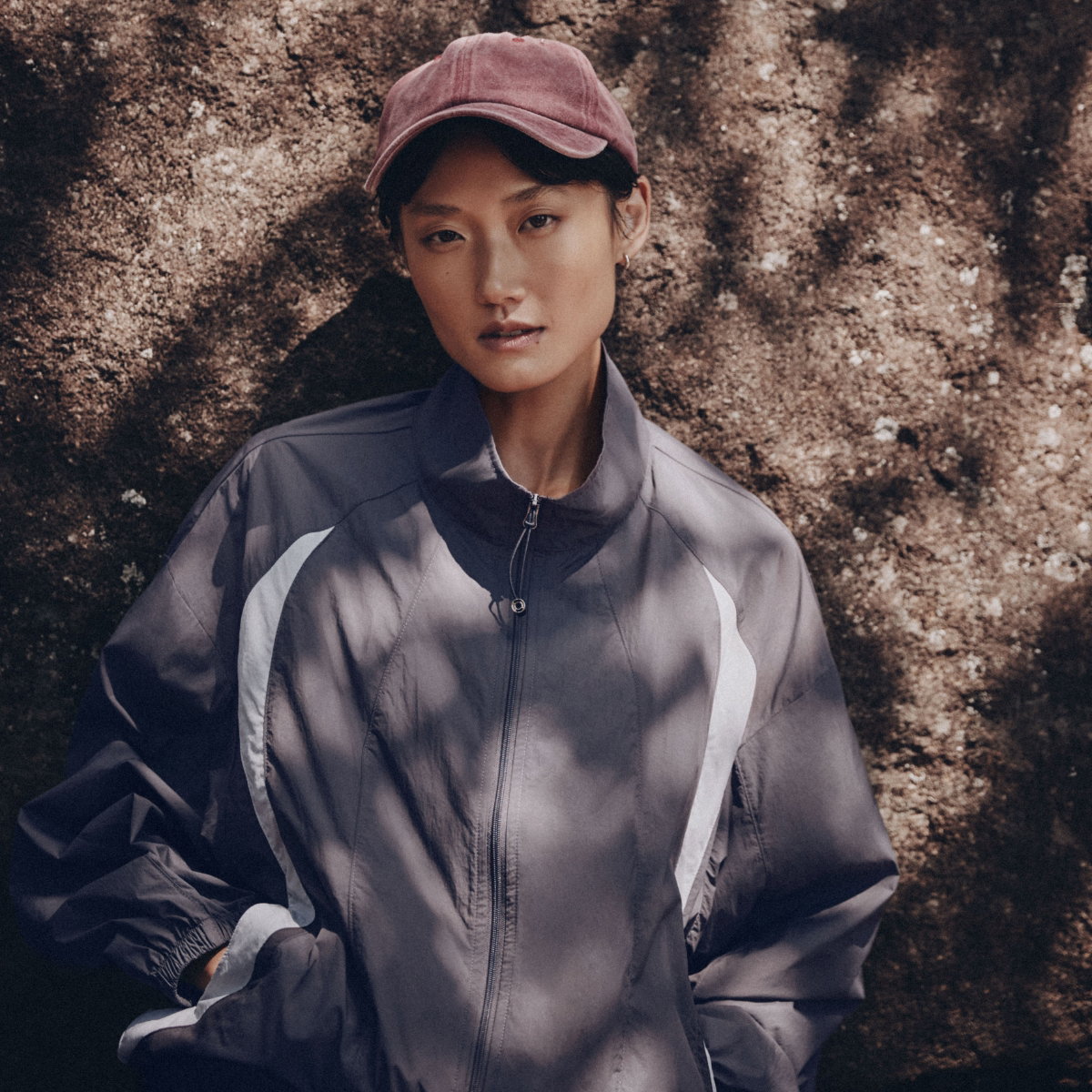 A woman is wearing a gray colour-block windbreaker jacket, Simons exclusive, at $89.95 instead of $135.00