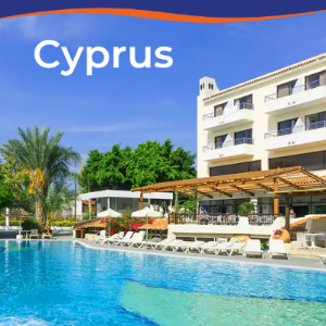 A sunny hotel pool area in Cyprus, surrounded by palm trees and lounge chairs.