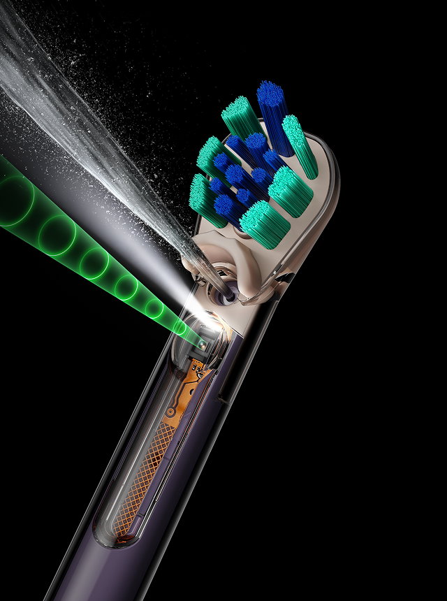 Dyson CameraJet toothbrush next to a smiling face.