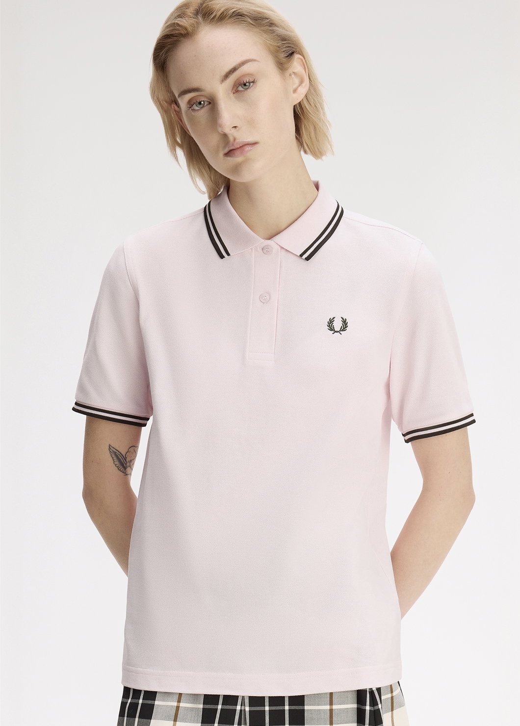 Female model wearing a G3600 Fred Perry Shirt in Iced Pink / Night Green / Night Green