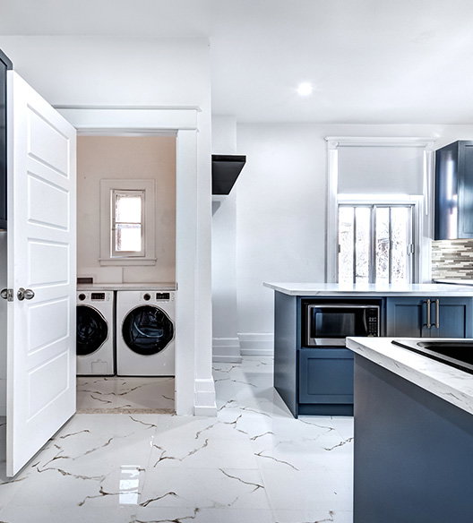 Modern home interior with a kitchen and a nearby laundry nook with a washer and dryer