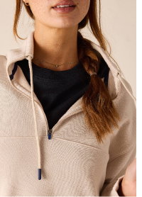 Close up image of a cream French terry quarter zip sweatshirt