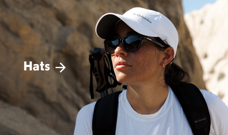 A woman in hiking gear walking in a desert with text: Hats
