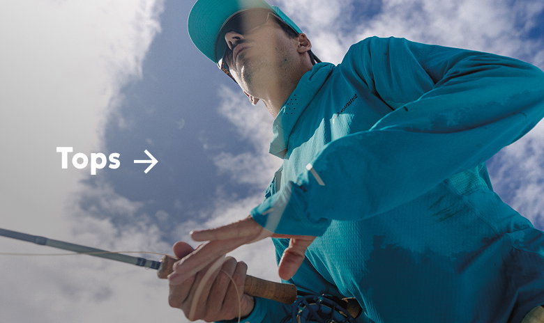 A man wearing a bright blue sun hoodie, holding a fishing rod with text: Tops