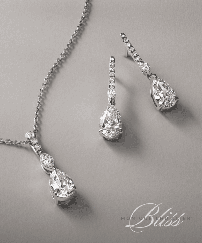 Pear-shaped diamond pendant necklace and drop earrings in white gold.