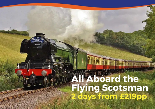 A steam locomotive, the Flying Scotsman, travels through lush green countryside.