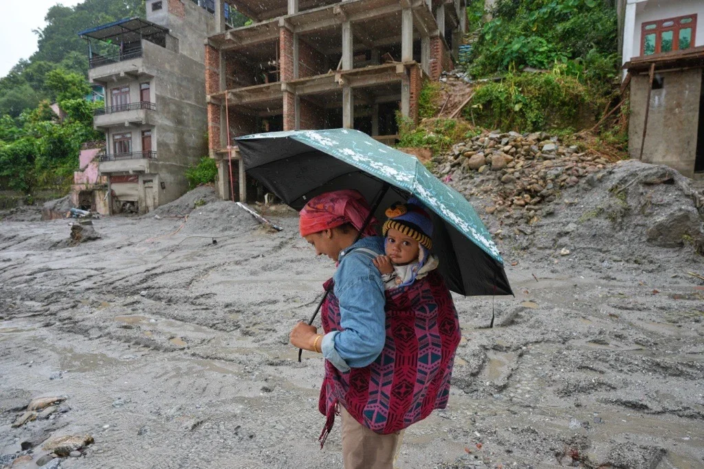 Rescue worker carrying flood survivor to safety