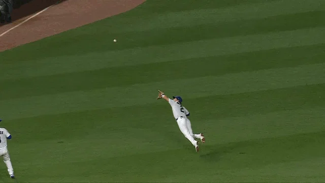 An animated gif of Cubs shortstop Nico Hoerner going airborne for a diving catch