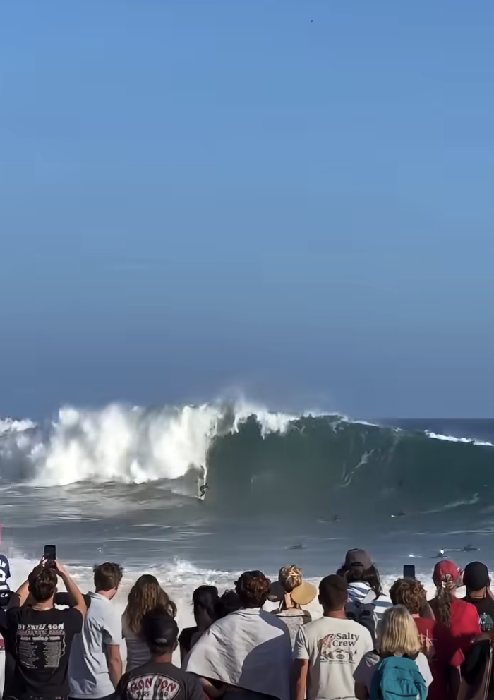 Surfer on wave with crowd watching