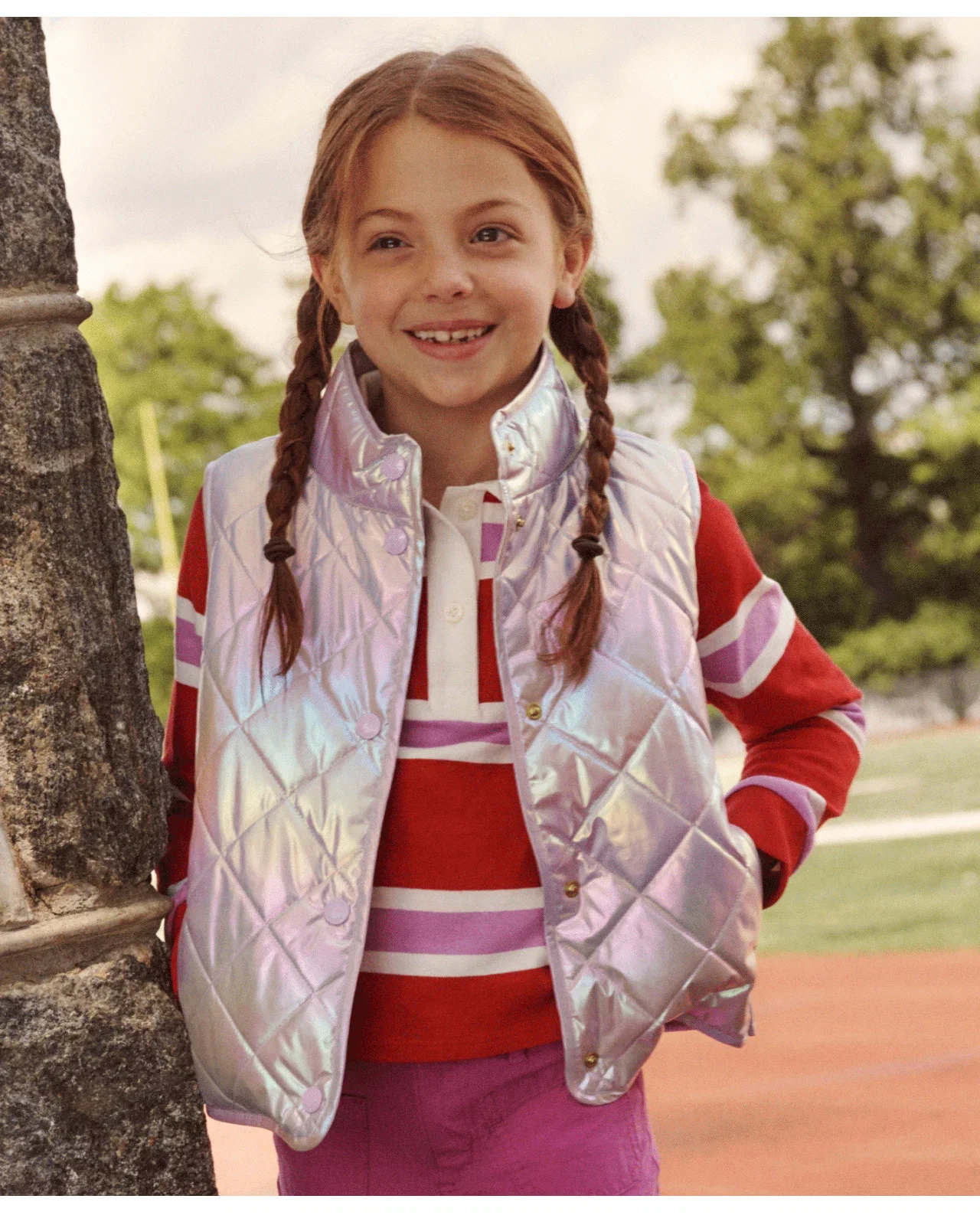 Metallic quilted puffer vest layered over a striped rugby sweatshirt.