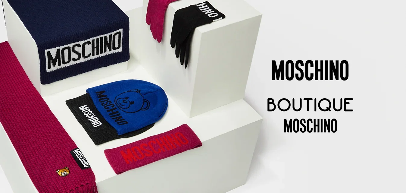 Collectie van Moschino-accessoires, waaronder een marineblauwe gestreepte muts, rode en zwarte sjaals, een blauwe muts en bijpassende handschoenen, allemaal met logo's.