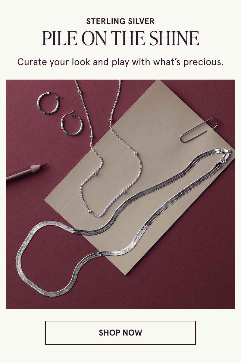 A pair of hoops and two necklaces rest on a sheet of paper. Sterling silver. Pile on the shine. Click here to shop now