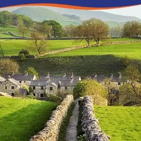 Lush green fields with stone walls and quaint cottages nestled in a picturesque valley.