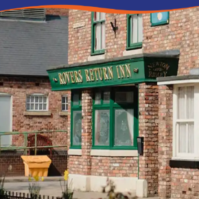 A brick pub facade with green signage reading "Rovers Return Inn" and a window display.