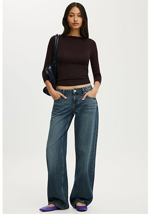 Woman wearing black long sleeve top and wide leg jeans