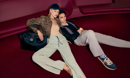 Two models reclining wearing Italian designer brands.