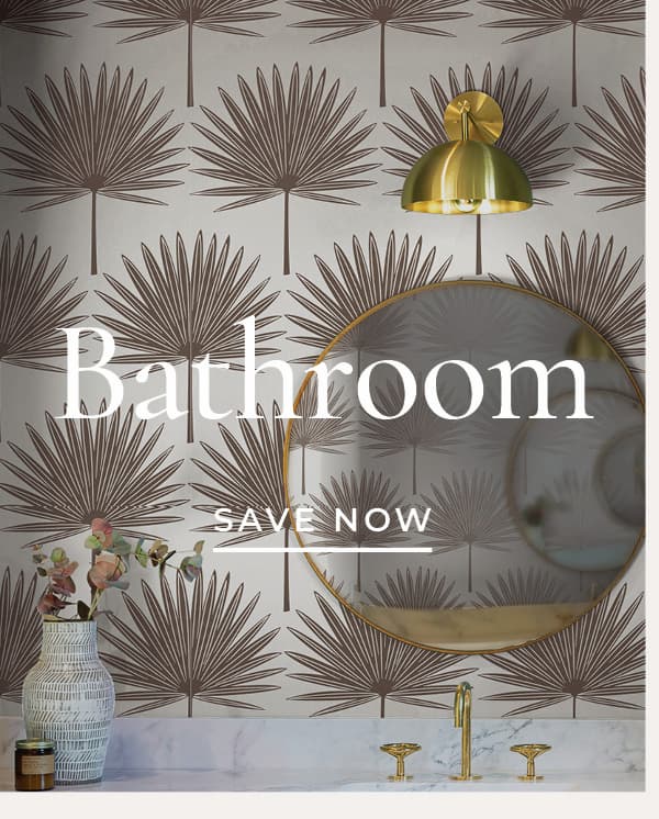Image of Tempaper's Stamped Palm wallpaper in cocoa installed in a bathroom with a gold rimmed mirror. Text overlay "Bathroom Save Now"