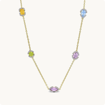 Multi Gemstone Station Necklace in Gold Plated: Gold necklace with five multicolored gemstone stations — citrine, peridot, amethyst, blue topaz, and pink sapphire — each surrounded by a halo of small diamonds.