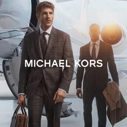 Twee mannen in op maat gemaakte pakken lopen langs een privéjet. De eerste man draagt een bruine leren tas, terwijl de tweede een beige overjas vasthoudt.
