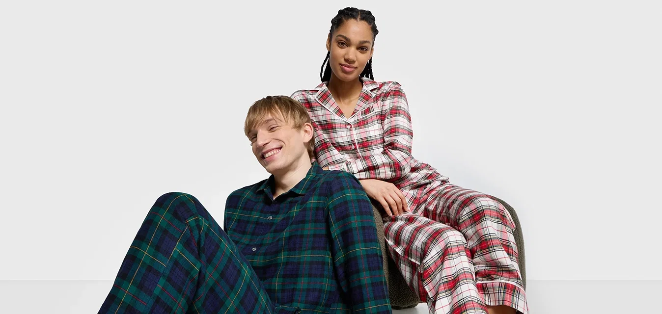 Geruit pyjamastel met een groen en navy ontwerp voor de man, en een rood en witte check voor de vrouw. Zachte stof met knoopaccenten.