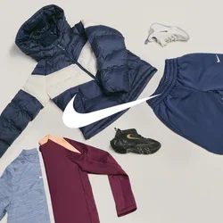 Donkerblauwe en beige gewatteerde jas, blauwe en kastanjebruine overhemden, marineblauwe joggingbroek, zwart-witte sneakers gerangschikt op een lichte achtergrond.