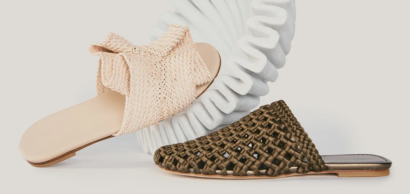 Twee slip-on sandalen, één beige met stoffen bovenwerk en één bruine met geweven design, afgebeeld tegen een effen lichte achtergrond.