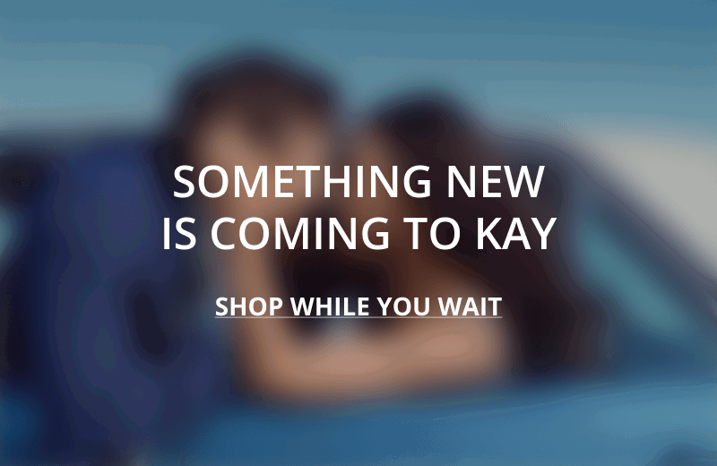 A blurred image of a couple embracing. Something new is coming to KAY. Click shop while you wait.