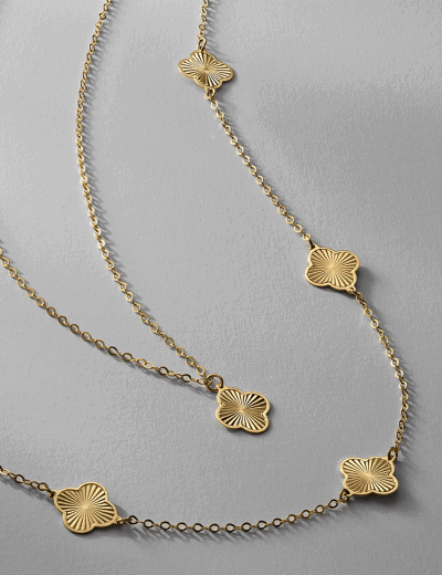 Gold station necklace featuring clover-shaped motifs on a fine chain.