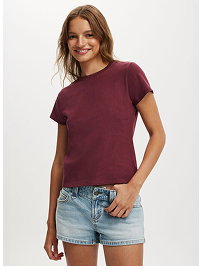 Woman wearing burgundy short sleeve tee and denim shorts