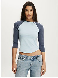 Woman wearing light blue baseball tee and light wash jeans