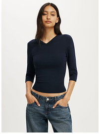 Woman wearing navy three-quarter sleeve v-neck top with jeans