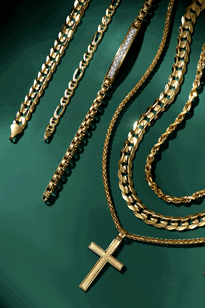 Various men’s chains and  necklaces on green background.