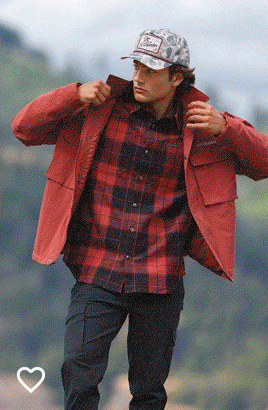 A man wearing a red and black flannel shirt and red jacket outside.